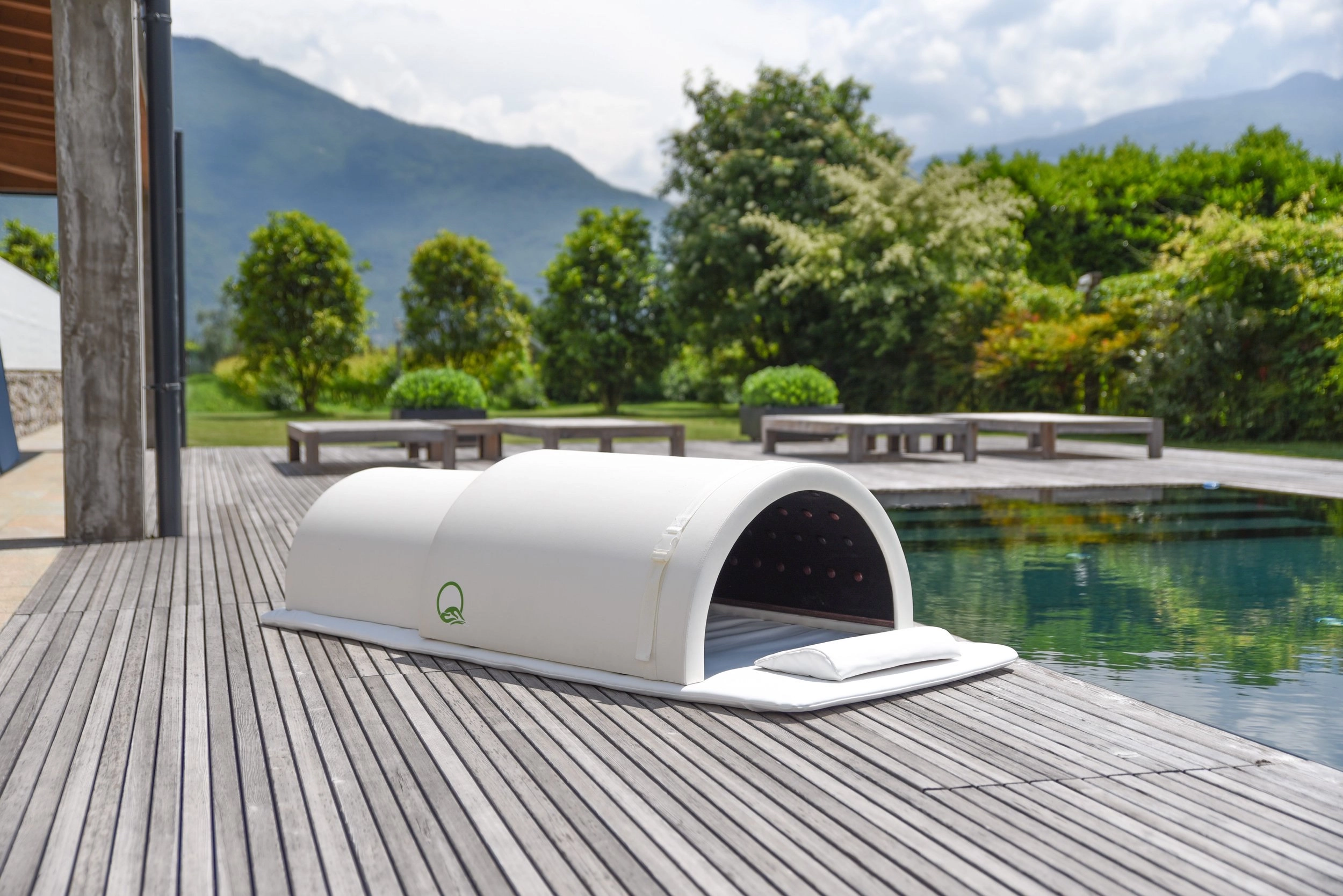 Sauna giapponese a infrarossi lontani all'aperto accanto a una piscina, con vista sulle montagne e un ambiente naturale